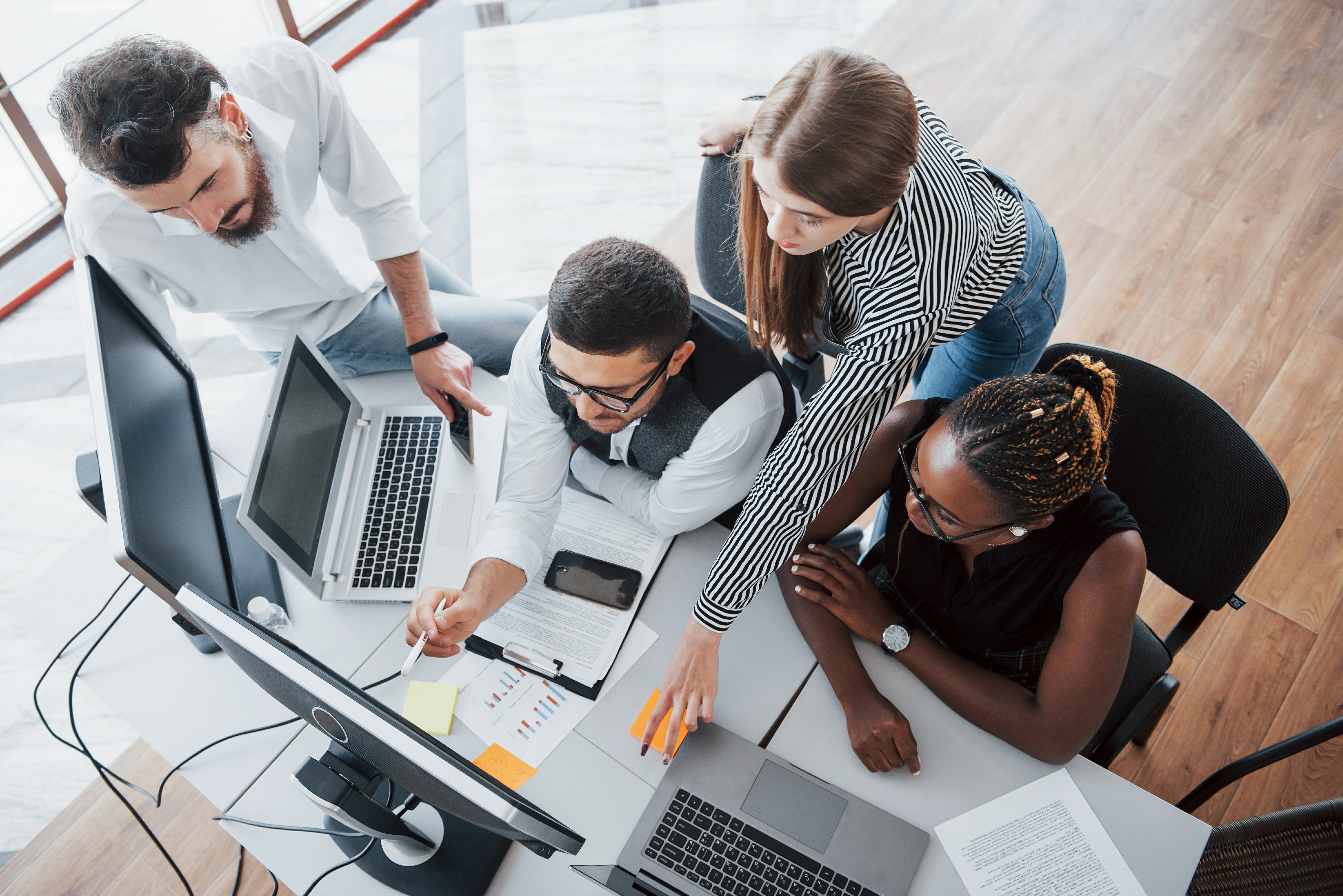 4 pessoas ao redor de uma mesa lendo roteiro de entrevista de emprego