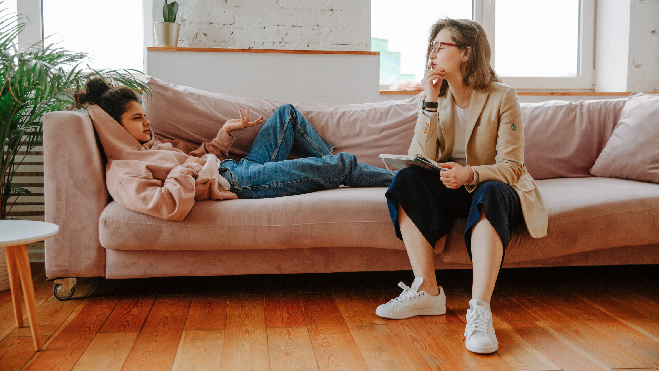 Duas mulheres conversando em um sofá, como em uma consulta.